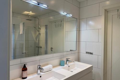 a bathroom with a sink and a large mirror at LofotenApartmentOne in Stamsund