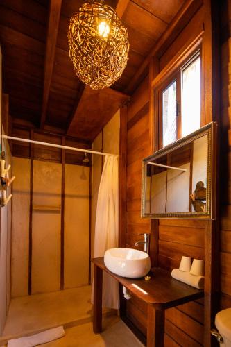 a bathroom with a sink and a mirror and a chandelier at Coconut by ÓOL Hotels in Holbox Island