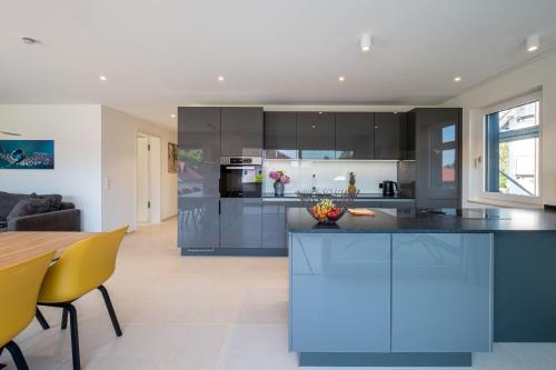 a large kitchen with blue cabinets and a table at Domizil Relax - Fewo Seeluft in ruhiger zentraler Lage in Überlingen