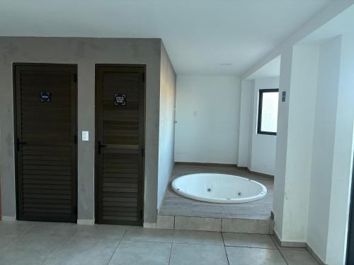 a room with two doors and a bath tub at Flat na Praia dos Carneiros - Resort Max Carneiros Suítes in Tamandaré