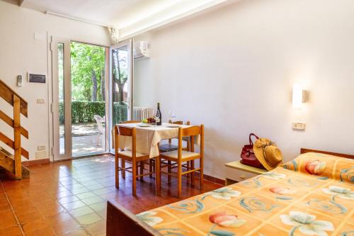 a bedroom with a table and a bed and a dining room at Borgo San Giorgio by La Principina in Grosseto