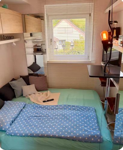 a bed in a small room with a window at Mini Apartment in Öhningen