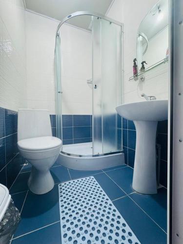 a bathroom with a toilet and a sink and a shower at Guest house BIKA in Chon-Sary-Oy