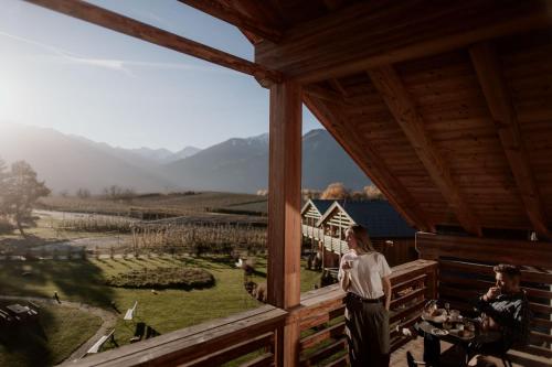 a woman standing on the balcony of a house with a view at Kessler's Mountain Lodge in Natz-Schabs