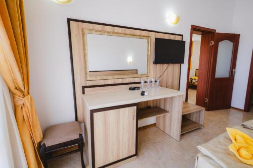 a room with a desk with a mirror and a television at Stefanov 2 Hotel in Lozenets