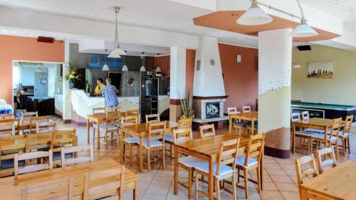 a restaurant with wooden tables and chairs and a fireplace at B&B Artemida in Ostrowo