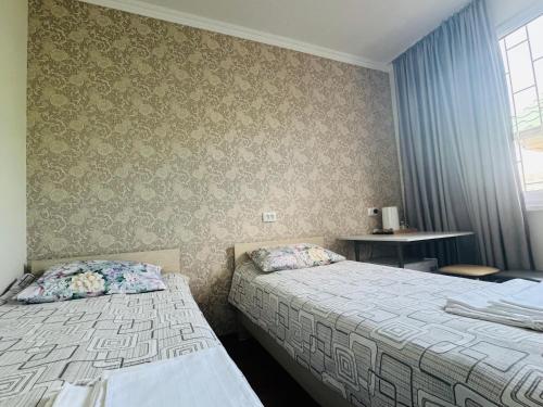a hotel room with two beds and a window at Guest house BIKA in Chon-Sary-Oy