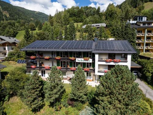 an apartment building with solar panels on the roof at Gästehaus Schusser an der Therme, Frühstück, Doppelzimmer und Ferienwohnung in Bad Kleinkirchheim
