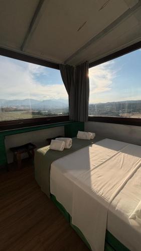 a bedroom with two beds and a large window at agriturismo Piccolo Albero in Loreto Aprutino