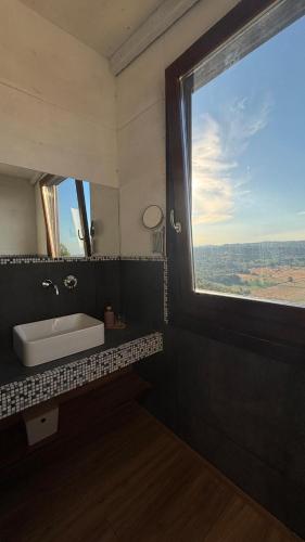 a bathroom with a sink and a large window at agriturismo Piccolo Albero in Loreto Aprutino