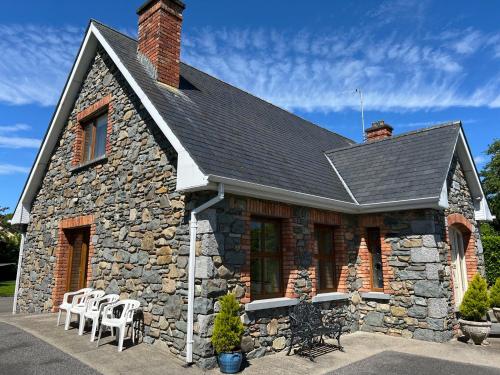 a stone house with white chairs in front of it at Laurel Lodge in Virginia