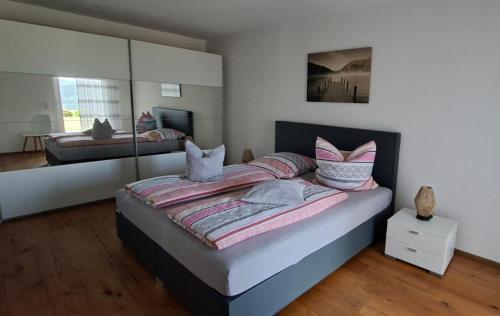 a bedroom with a large bed with a mirror at Hochsalerblick in Laufenburg