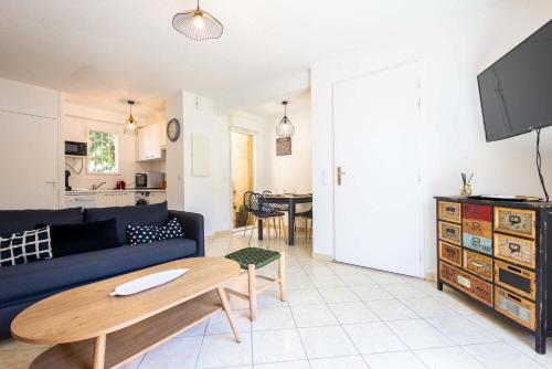 a living room with a blue couch and a table at Valras-Loc Maison T3 in Valras-Plage