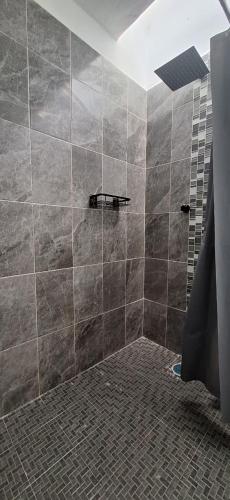 a bathroom with a shower with tiled walls and a shower at Casa Las Luces in Nanacamilpa