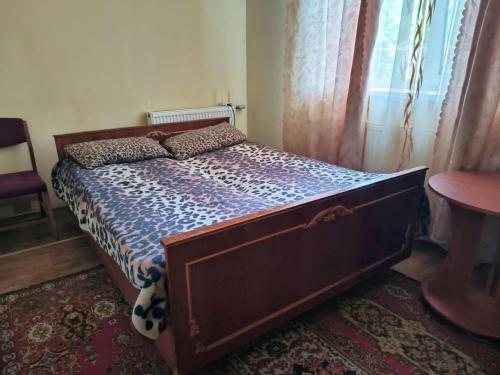 a bedroom with a bed with a wooden frame at Петропавловская 16 in Okhtyrka