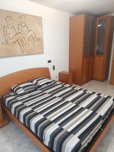 a bed in a bedroom with a painting on the wall at APARTAMENTO QUINTO in Valderrobres