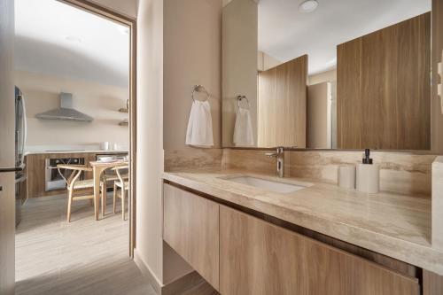 a bathroom with a sink and a kitchen at Bohari Las Arenas in Cabo San Lucas