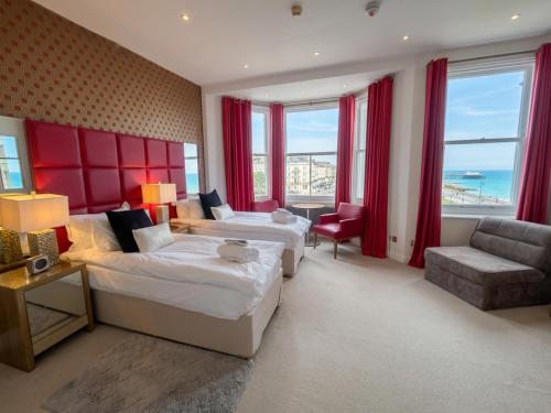 a hotel room with two beds and a couch at Hastings House 9-Bedroom Holiday House in Hastings