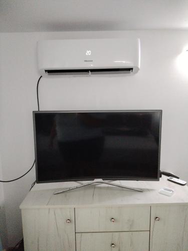 a large flat screen tv sitting on top of a cabinet at Sofia's home in Piatra Neamţ