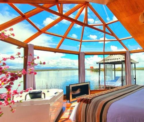 a bedroom with a large window with a view of the water at KAY PACHA LODGE Uros in Puno
