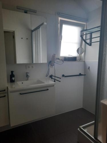a white kitchen with a sink and a window at Maison Maritime in Middelkerke