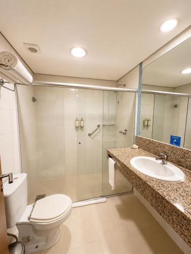 a bathroom with a shower and a toilet and a sink at Blue Tree Premium Manaus in Manaus