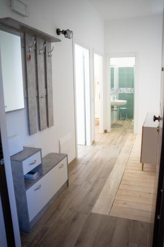 a living room with white walls and a wooden floor at 99 Rooms in LʼAquila