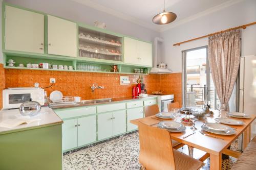 a kitchen with green cabinets and a wooden table at Giorgos House in Nafpaktos