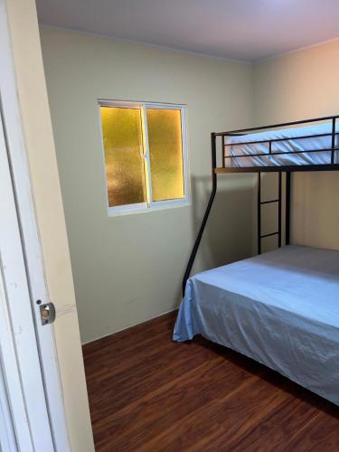 a bedroom with a bunk bed and a window at Villa Clarice in Bonao