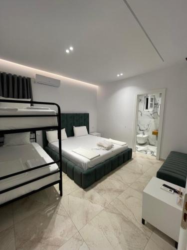 a bedroom with two bunk beds and a living room at Vila Elezi 2 in Tirana