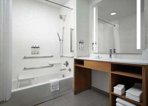 a white bathroom with a tub and a sink at Holiday Inn - Cincinnati - Liberty Way by IHG in West Chester