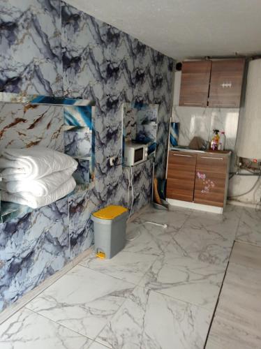 a room with a marble wall with a bed and a trash can at Апартамент in Razgrad