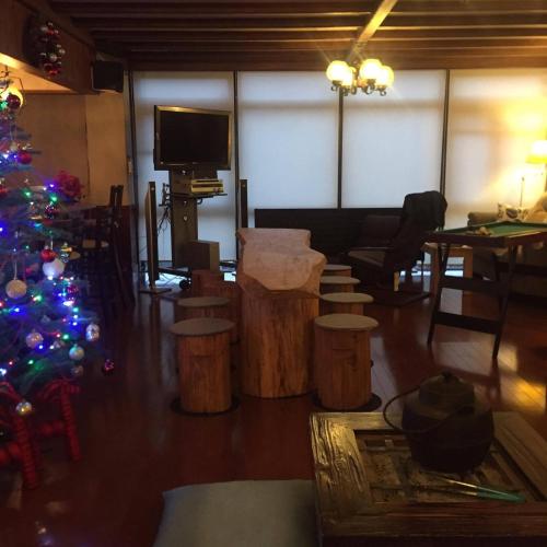 a living room with a christmas tree and stools at Hotel Tae Windsor in Myoko