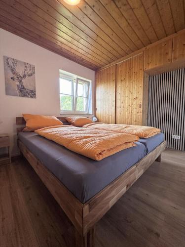 a large bed in a room with wooden walls at Ferienhaus Kühlwein in Bad Goisern