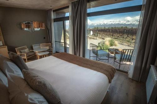a bedroom with a bed and a large window with a view at Andeluna Winery Lodge in Tupungato