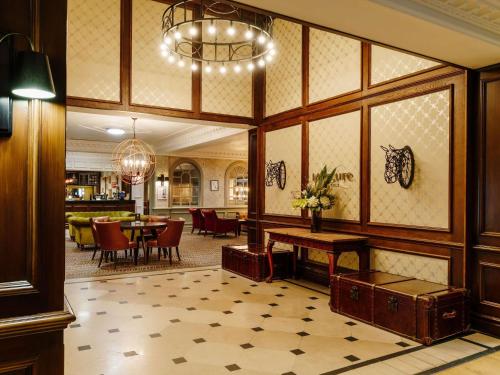 a lobby with a table and a dining room at Mercure Haydock Hotel in Haydock