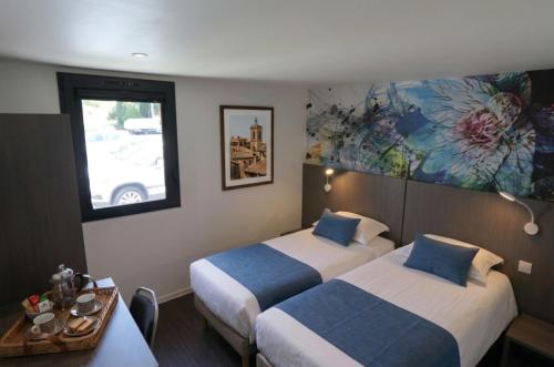 a hotel room with two beds and a window at Brit Hotel Montpellier Euromédecine in Montpellier