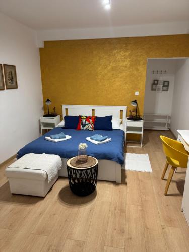 a bedroom with a blue bed and a yellow wall at Sweet home in Rab
