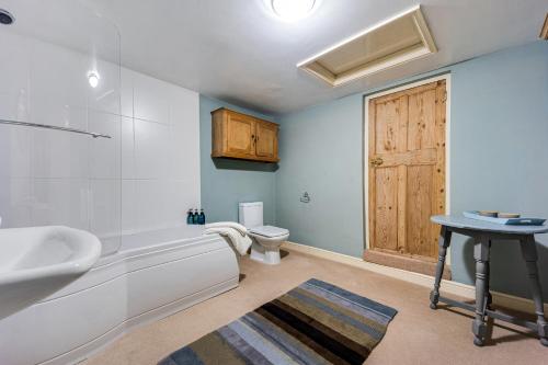 a bathroom with a tub and a sink and a toilet at The West Wing in Whitford