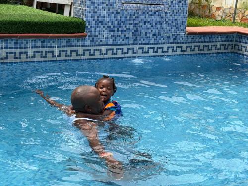 a boy and a girl in a swimming pool at Epa's Place in Awoyaya