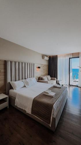 a bedroom with a large bed and a large window at Don Mare in Dhërmi