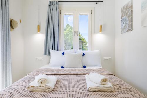 a bedroom with a bed with towels on it at Villa Aerys in Skopelos Town