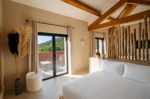 a bedroom with a white bed and a balcony at Casamore in Meria