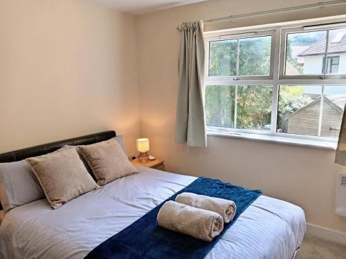 a bedroom with a bed with two towels on it at 2 Bedrooms Flat in Surrey, 30 min to London in Woking