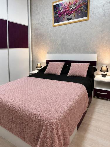 a bedroom with a pink bed with two pink pillows at ROYAL MIRAGE Militari Residence in Chiajna