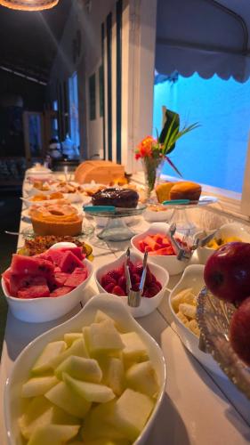 a table with many bowls of different types of food at Pousada jade in Pirenópolis