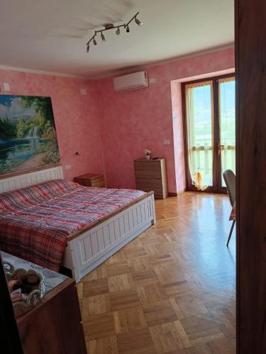 a bedroom with a bed in a room with pink walls at Locazione breve LE ROSE in Darfo