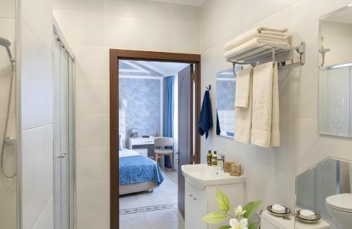 a bathroom with a sink and a toilet and a bed at Senator panoramic Hotel in Baku