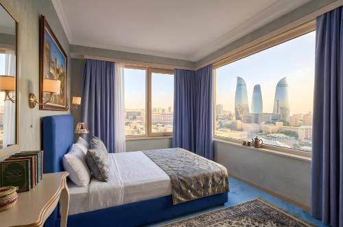 a hotel room with a bed and a large window at Senator panoramic Hotel in Baku