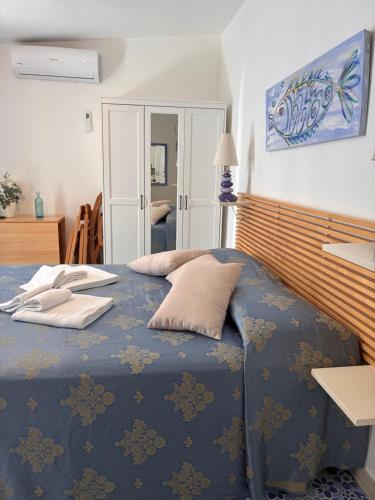 a bedroom with a blue bed with pillows on it at Vic e Vicariell in Gaeta